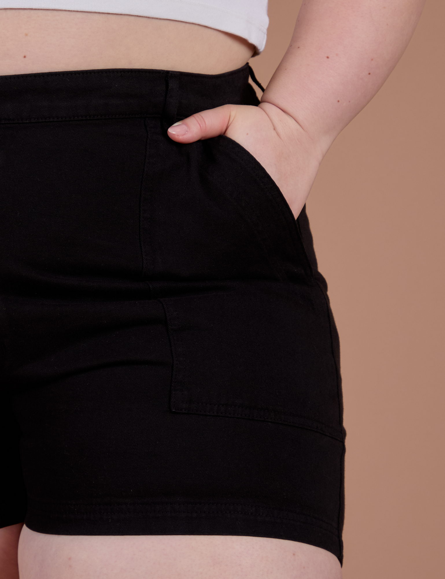 Close up of Ashley's hand in the front pocket of Classic Work Shorts in Basic Black