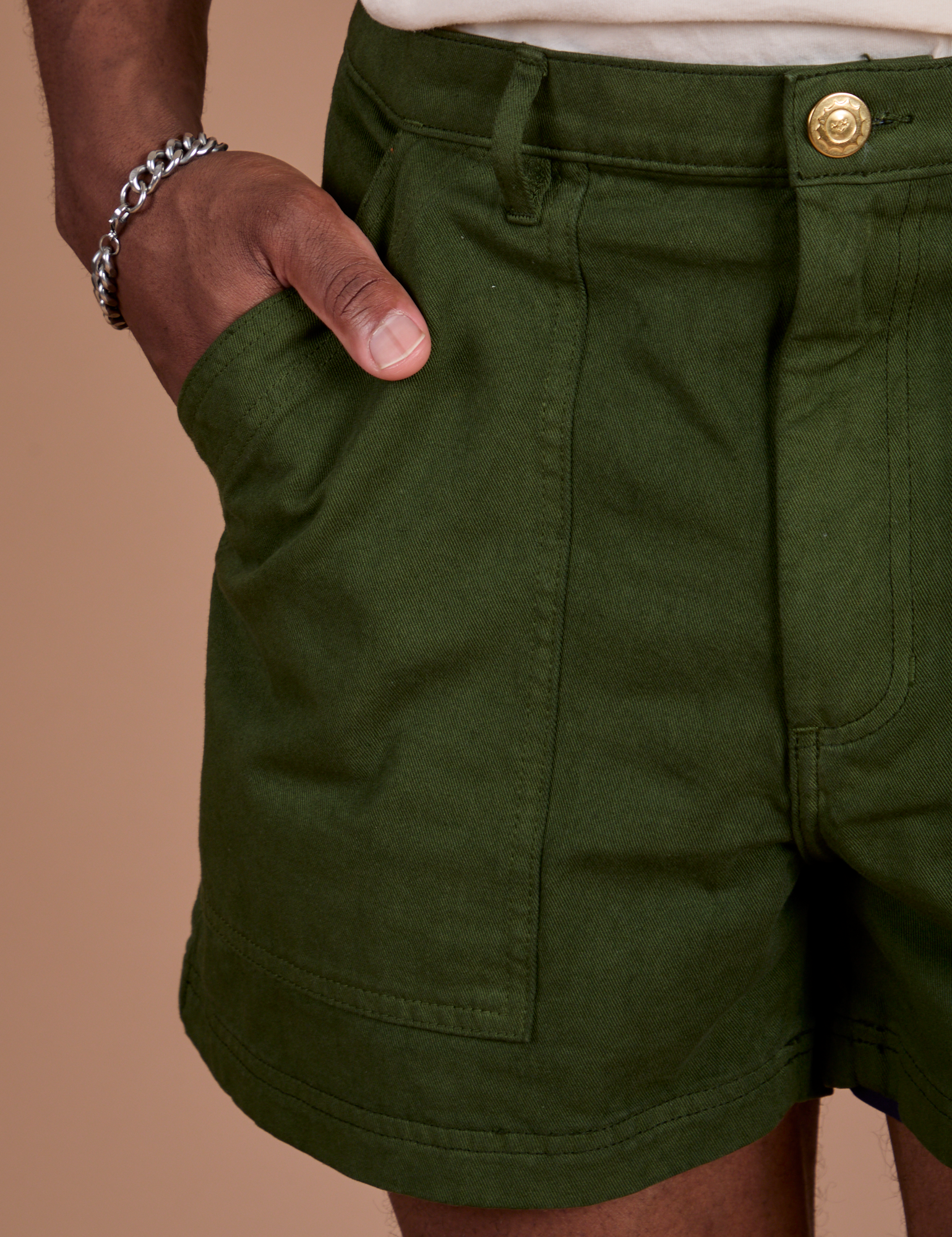 Close up of Isaac's hand in the front pocket of Classic Work Shorts in Evergreen