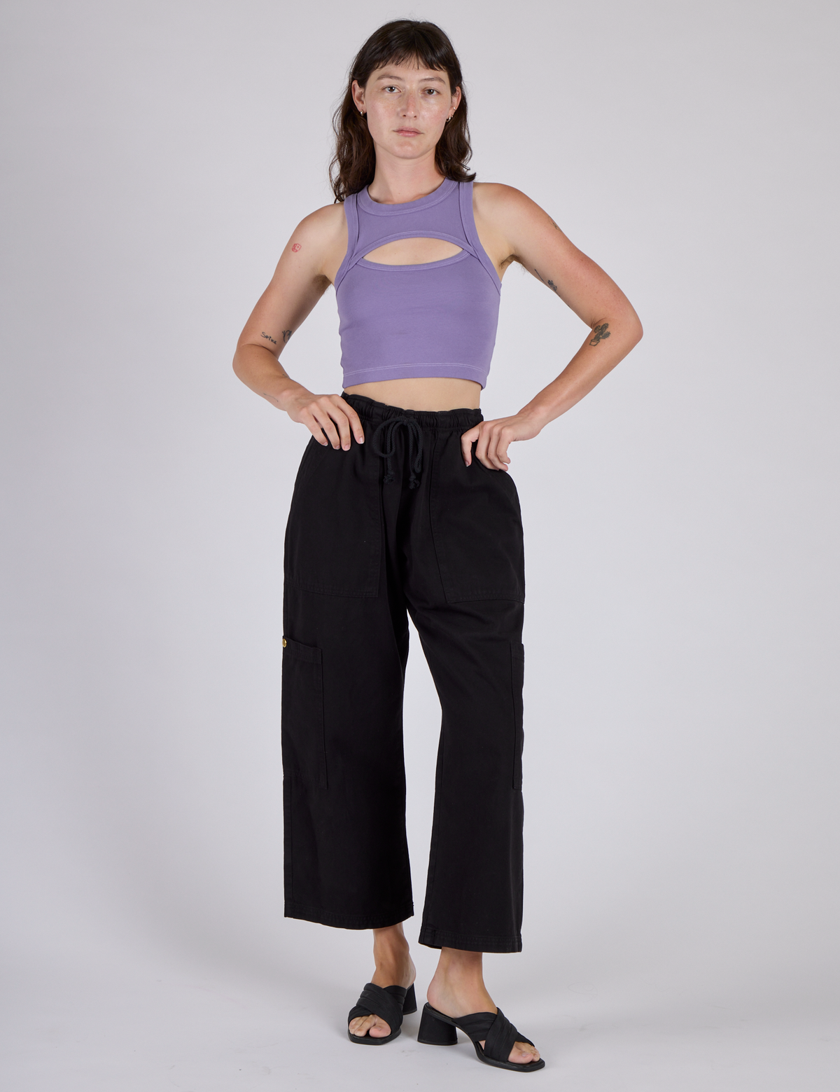 Alex is wearing the Faded Grape Porthole Tank and Black Cargo Drop Pocket Pants