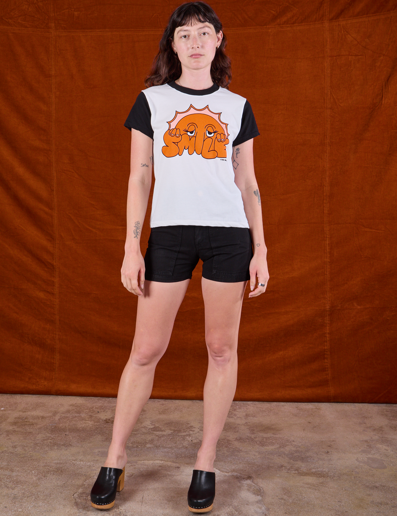 Alex is wearing Anniversary Tee in Smile paired with black Work Shorts