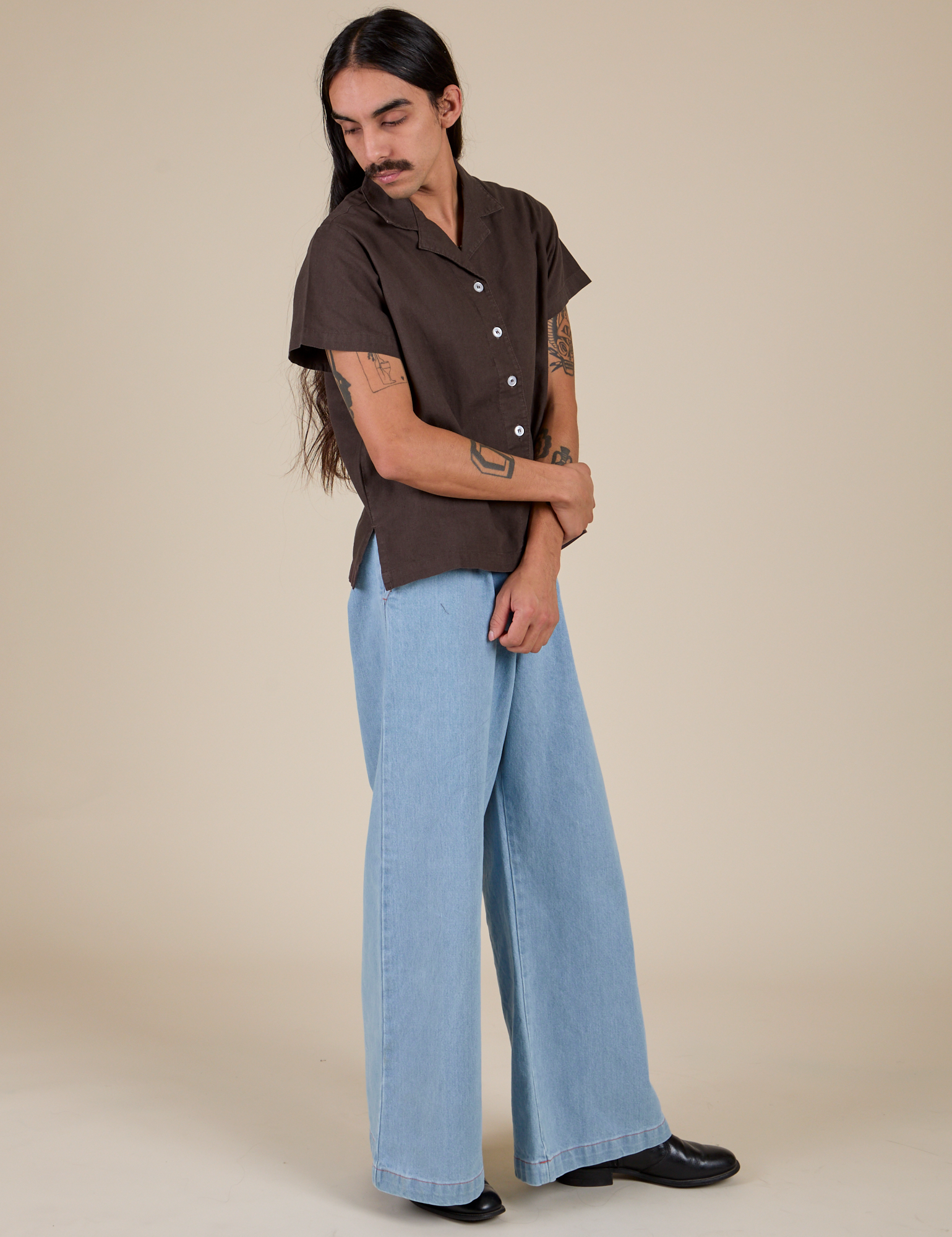 Side view of Pantry Button-Up in Espresso Brown and light wash Indigo Wide Leg Trousers on Anthony