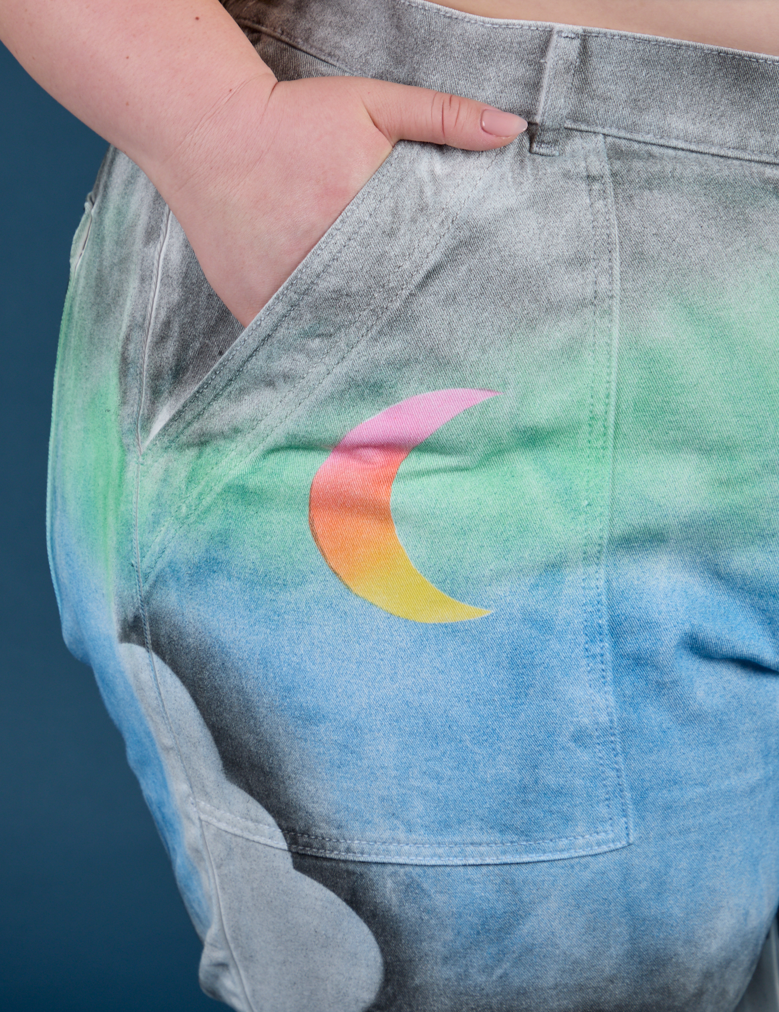 Close up of Ashley's hand in the front pocket of Work Pants in Night Sky Airbrush