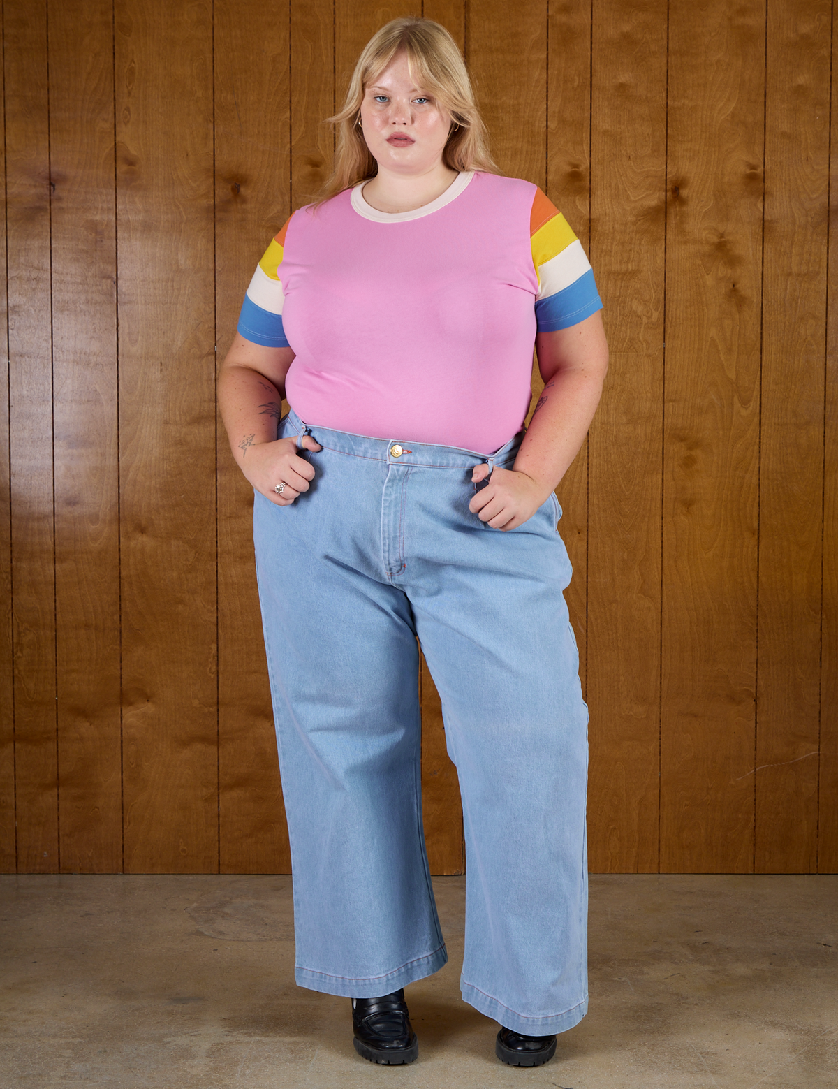 Juliet is wearing  Calypso Tee in Bubblegum Multi tucked into light wash Denim Wide Leg Trousers