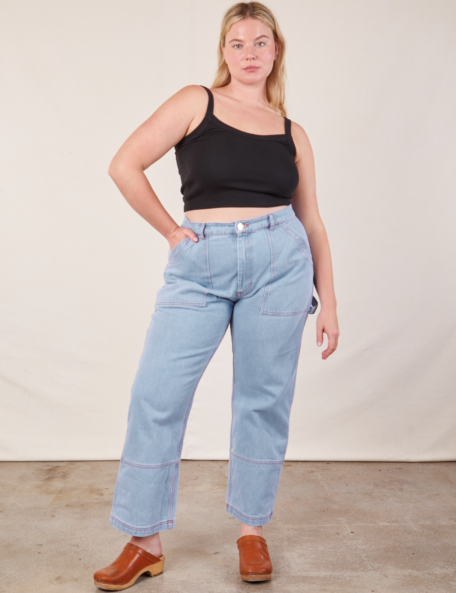 Lish is wearing Cropped Cami in Basic Black and light wash Carpenter Jeans