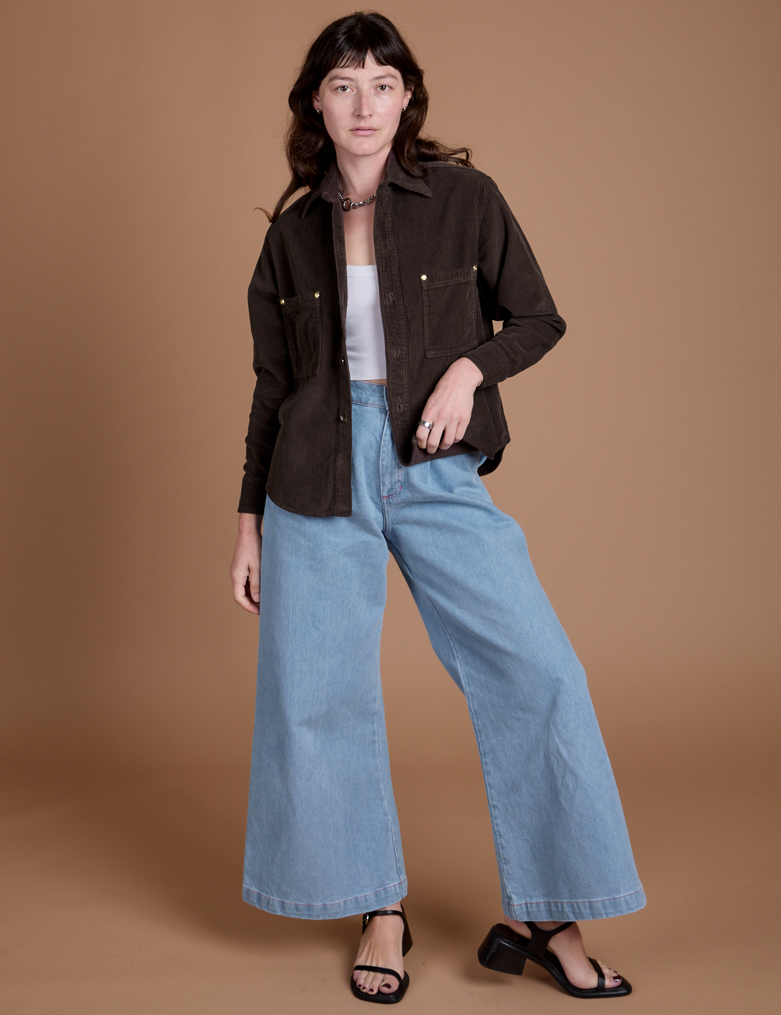 Alex is wearing Cropped Corduroy Overshirt in Espresso Brown and light wash Indigo Wide Leg Trousers