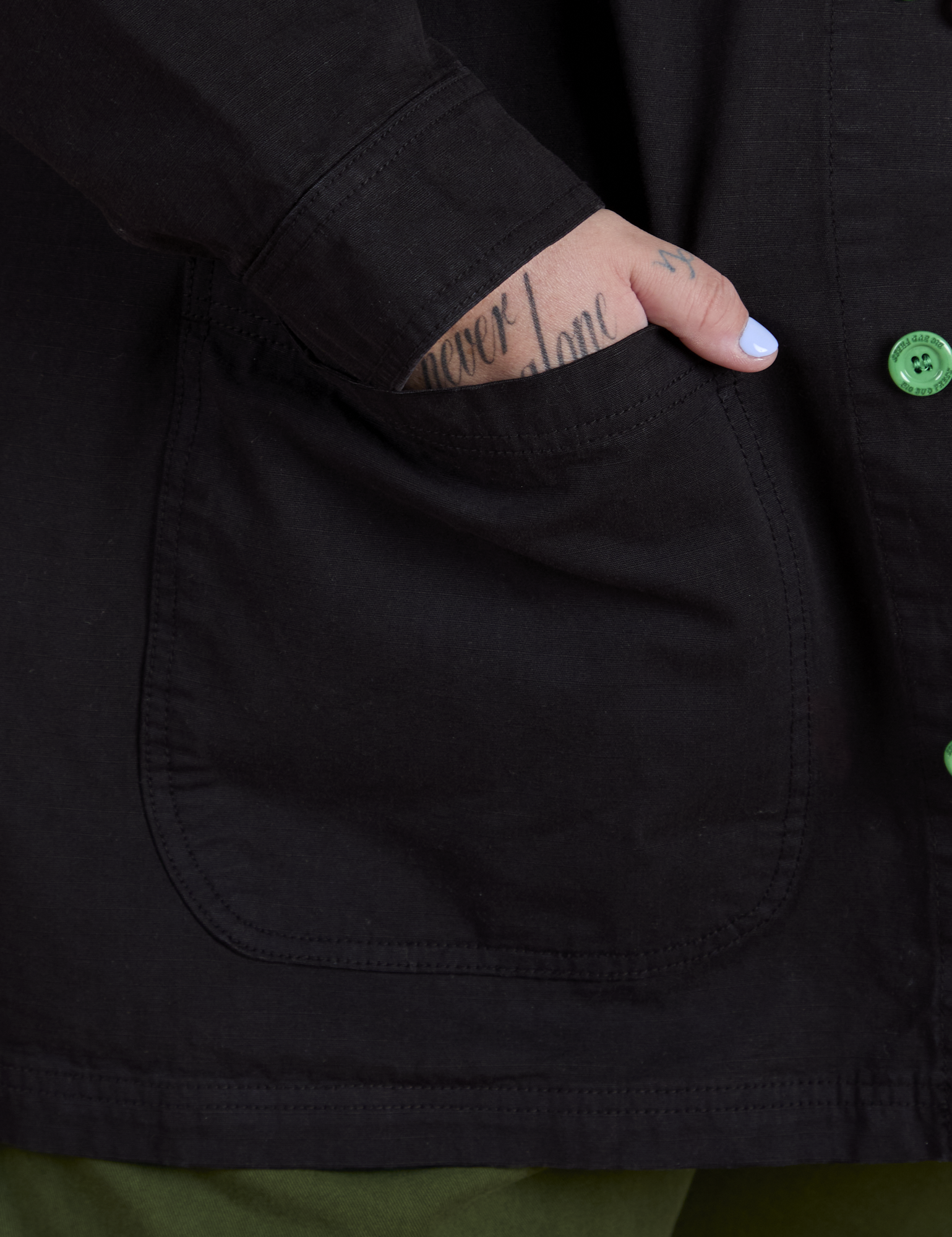 Close up of Sam's hand in the front pocket of Ripstop Field Coat in Basic Black