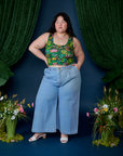Ashley is wearing Cropped Tank Top in Pond Party and light wash Indigo Wide Leg Trousers