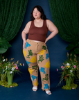 Ashley is wearing Paintstamped Work Pants in Froggy and fudgesicle brown Cropped Tank