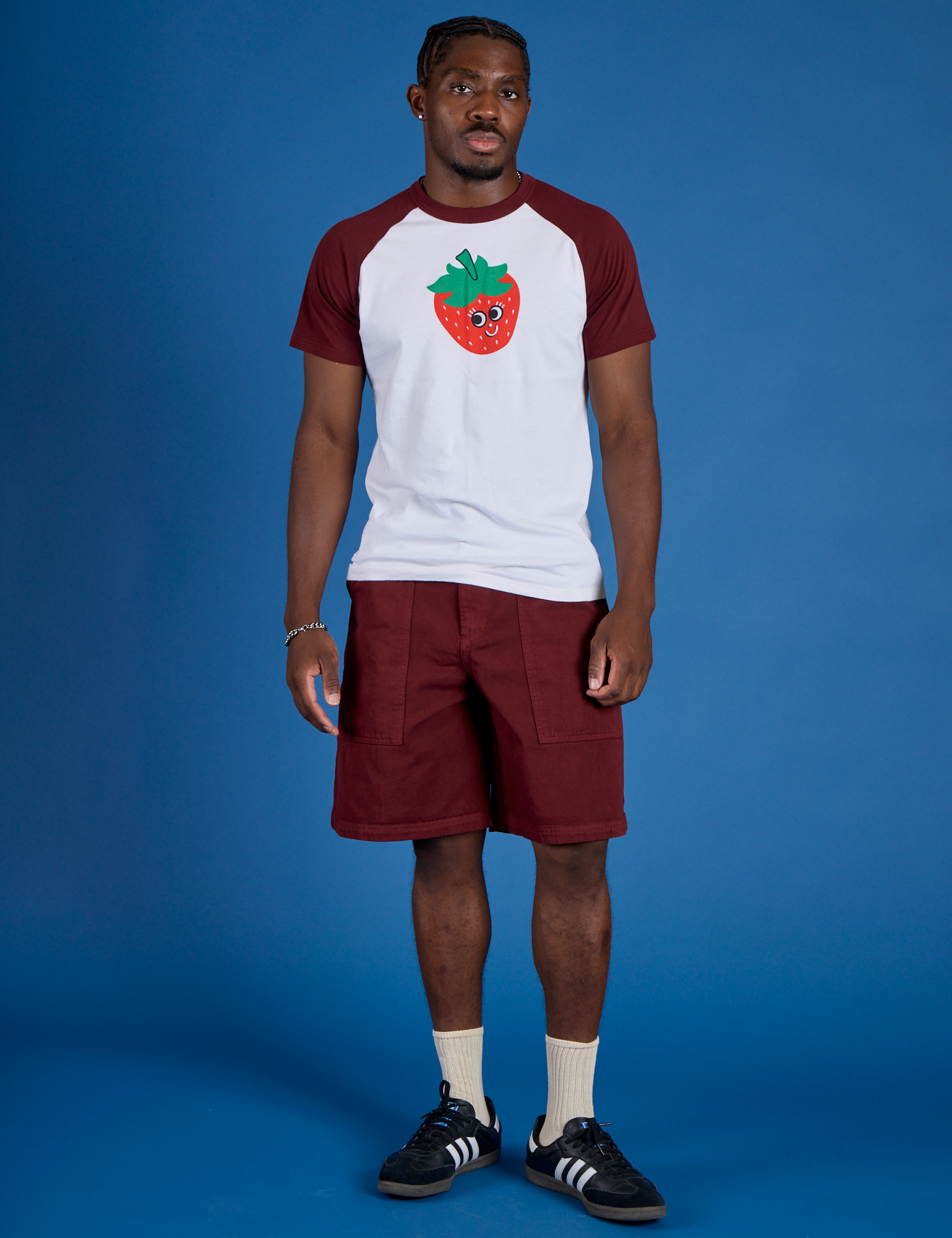 Isaac is wearing Produce Raglan Tee in Strawberry