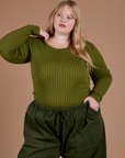 Juliet is wearing Gingham Long Sleeve Baby Tee in Summer Olive 
