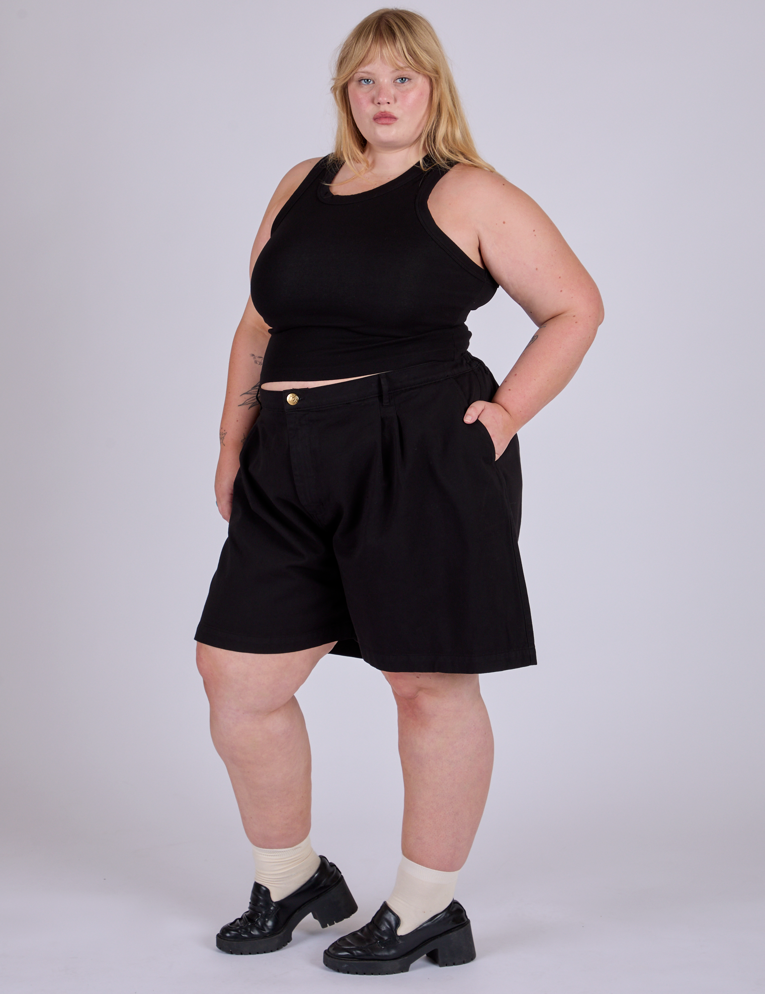 Angled front view of Pleated Trouser Shorts in Basic Black and black Racerback Tank