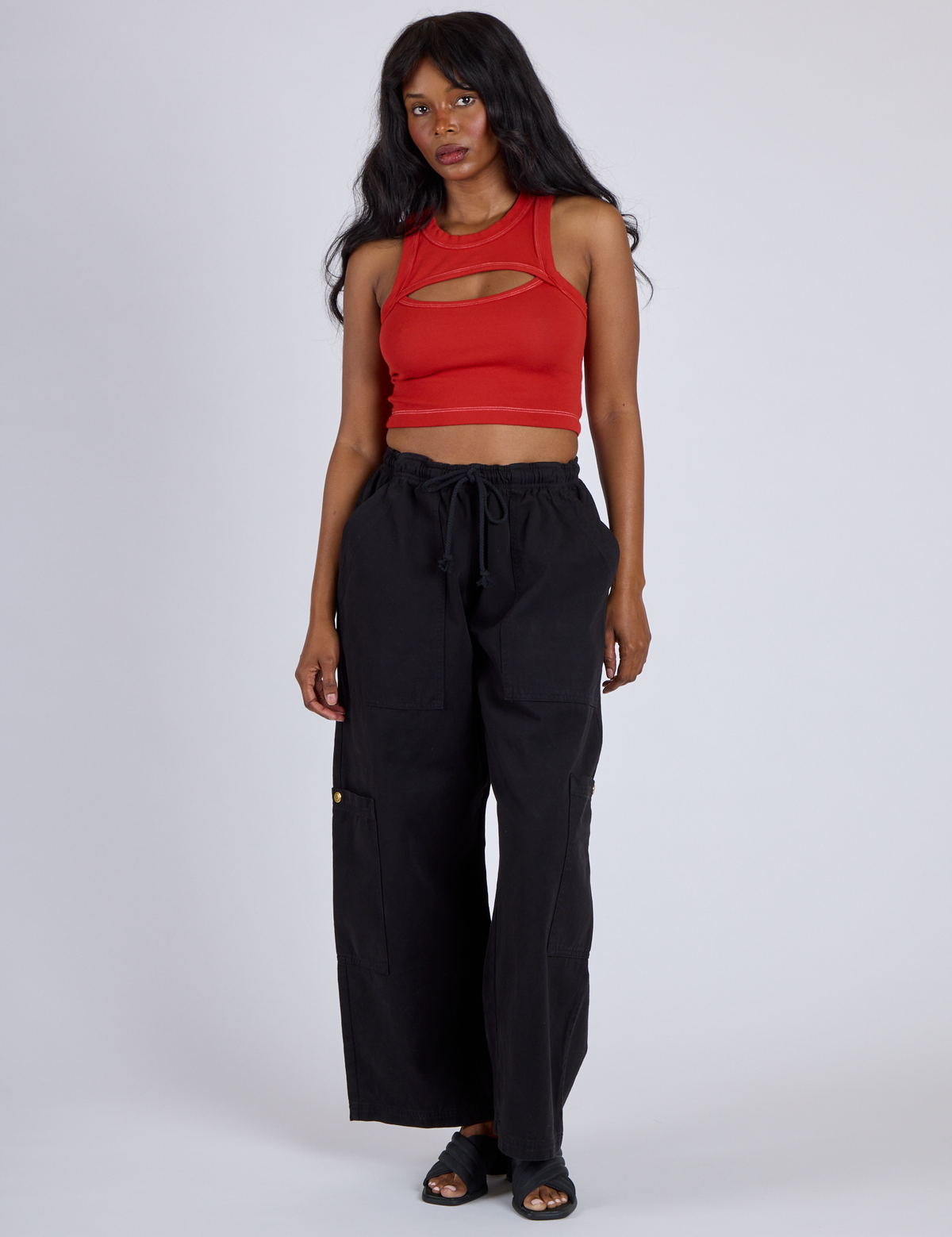 Kandia is wearing Porthole Tank in Mustang Red and Black Drop Pocket Cargo Pants