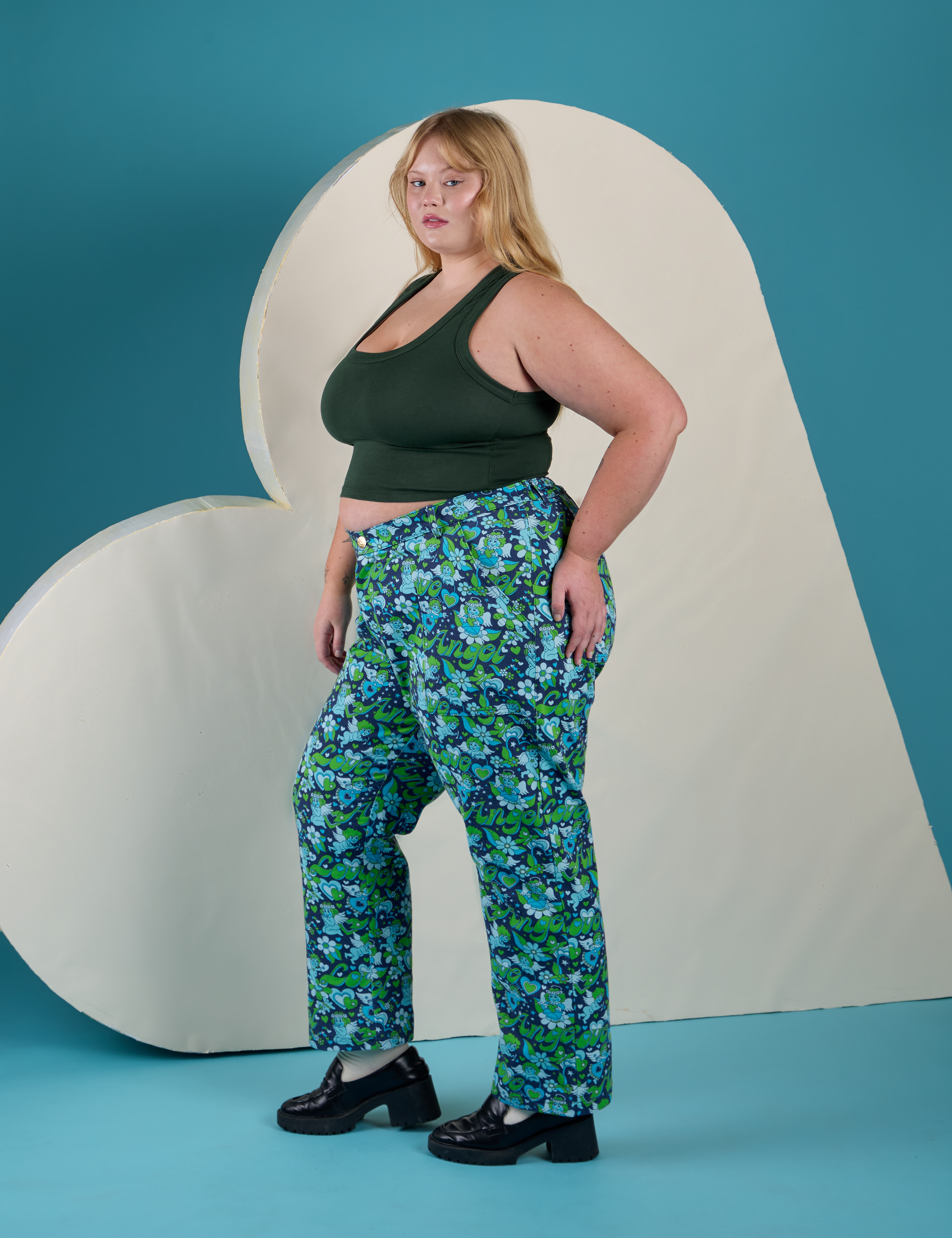 Side view of Work Pants in Angel Print and swamp green Cropped Tank on Juliet