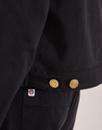 Close up of custom brass button snaps on the Mechanic Jacket in Basic Black