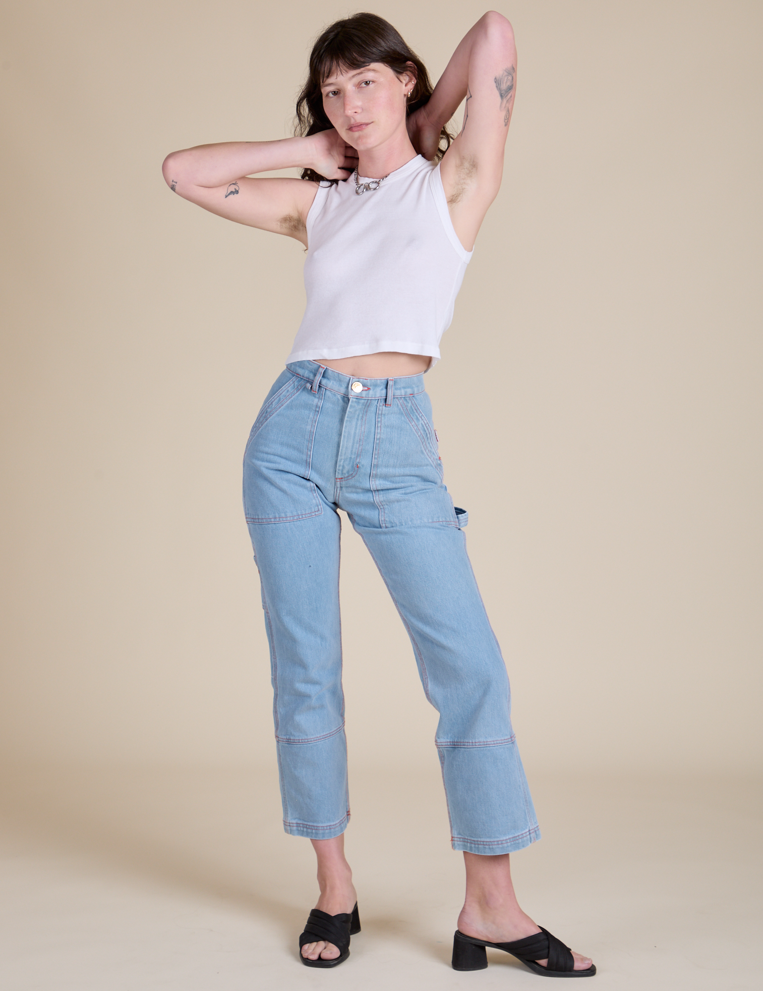 Alex is wearing Muscle Tee in Vintage Tee White paired with light wash Carpenter Jeans