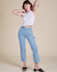 Alex is wearing Muscle Tee in Vintage Tee White paired with light wash Carpenter Jeans