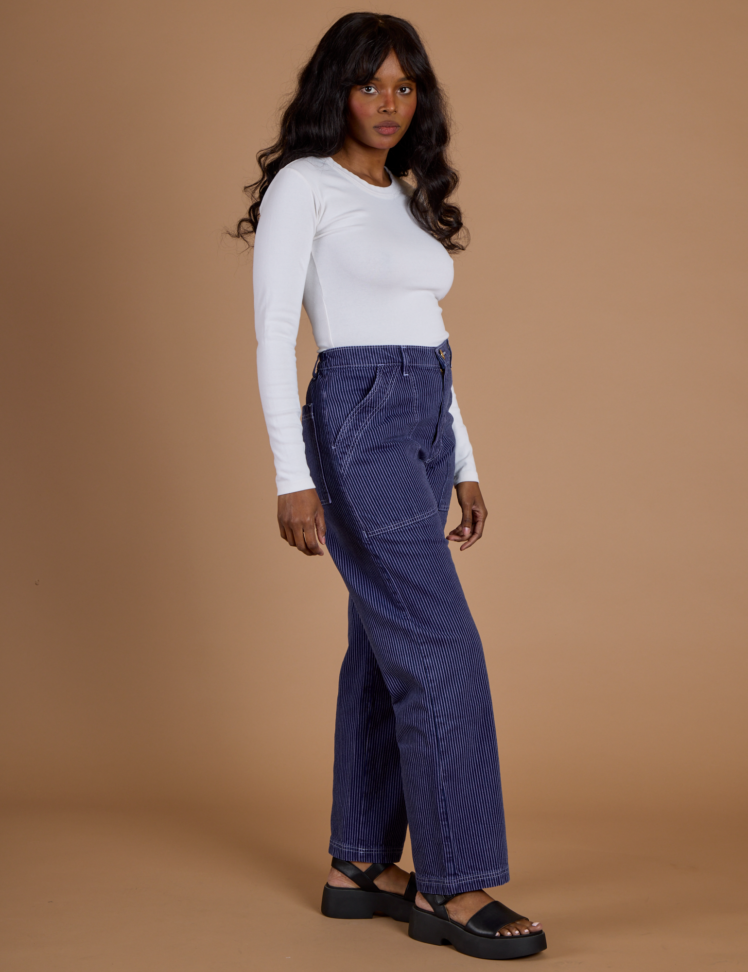 Side view of Railroad Denim Work Pants in Faded Grape Overdye and vintage tee white Long Sleeve Baby Tee