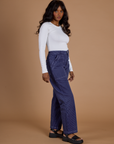 Side view of Railroad Denim Work Pants in Faded Grape Overdye and vintage tee white Long Sleeve Baby Tee