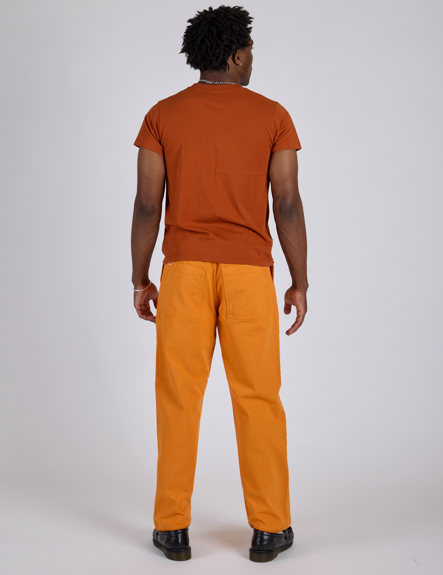 Back view of Work Pants in Creamsicle Orange and burnt terracotta Organic Vintage Tee on Isaac