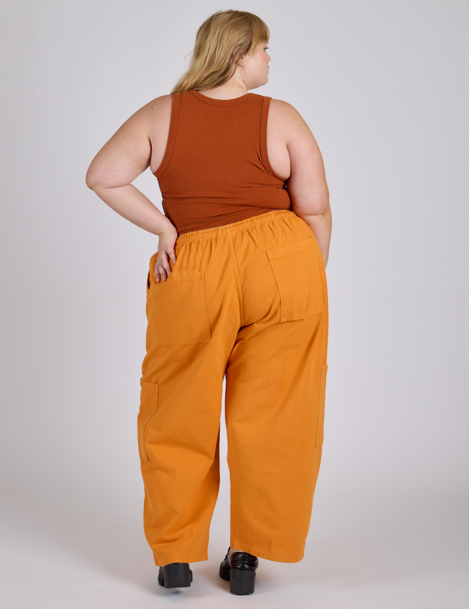 Back view of Drop Pocket Cargo Pants in Creamsicle Orange and burnt terracotta Cropped Tank on Juliet