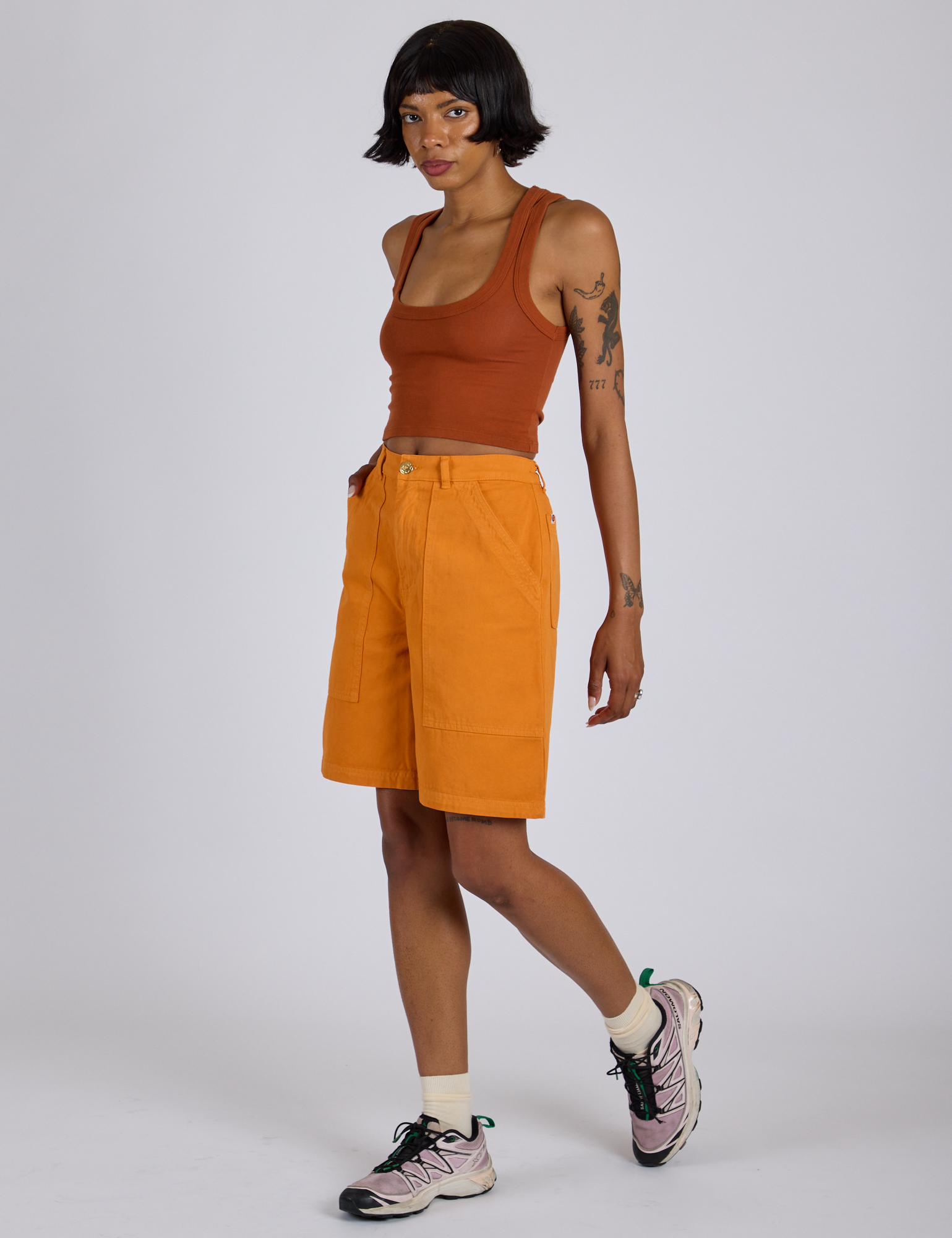 Angled front view of Longline Work Shorts in Creamsicle Orange and burnt terracotta Cropped Tank