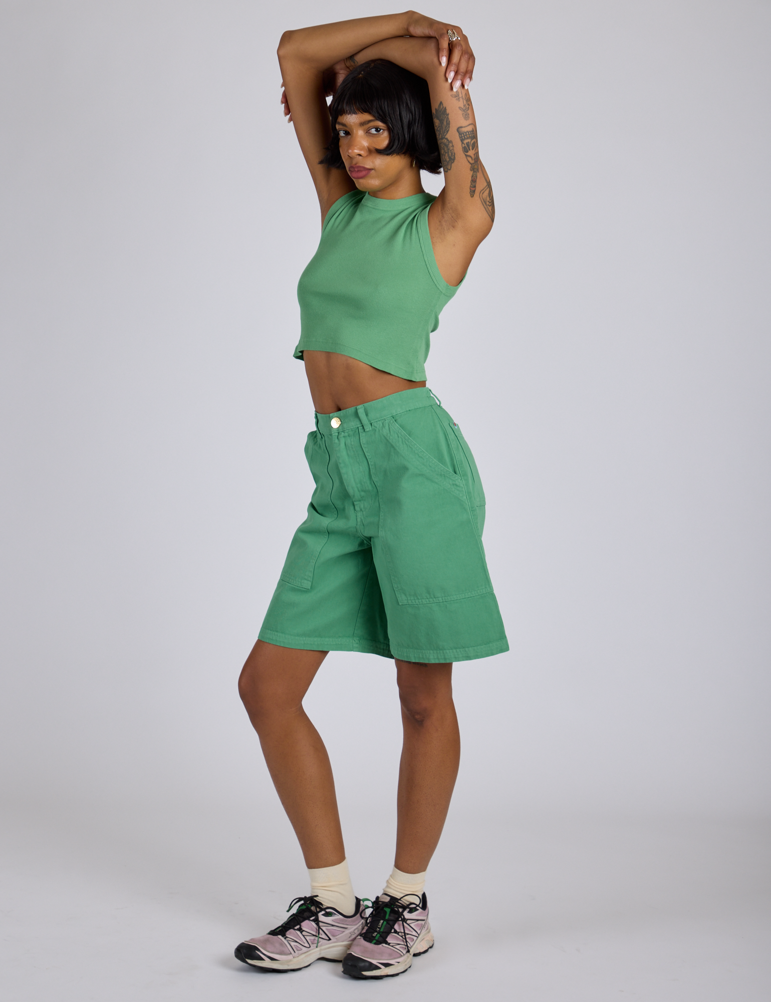 Angled front view of Longline Work Shorts in Seafoam Green and matching Muscle Tee on Kira
