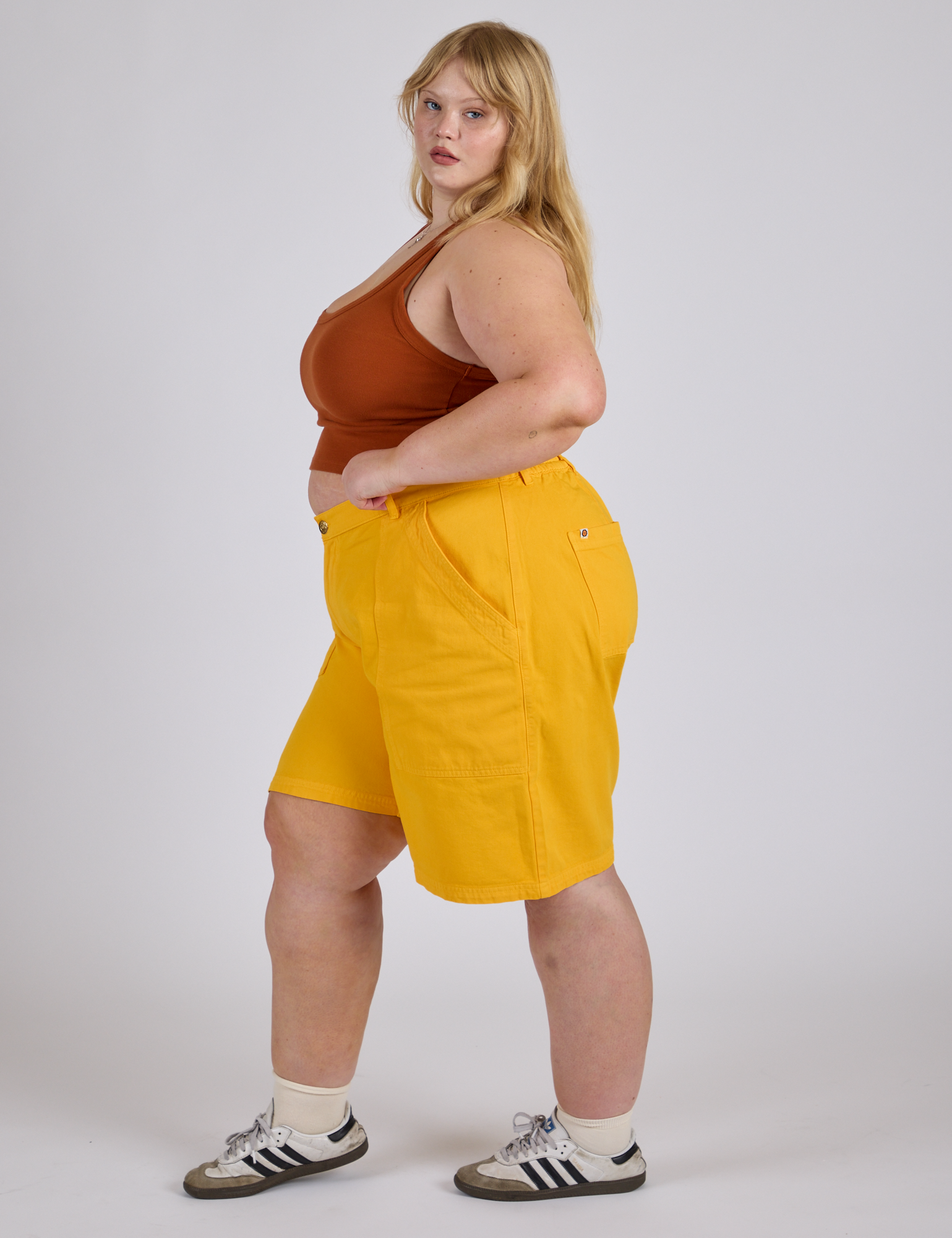 Side view of Longline Work Shorts in Sunshine Yellow and burnt terracotta Cropped Tank on Juliet