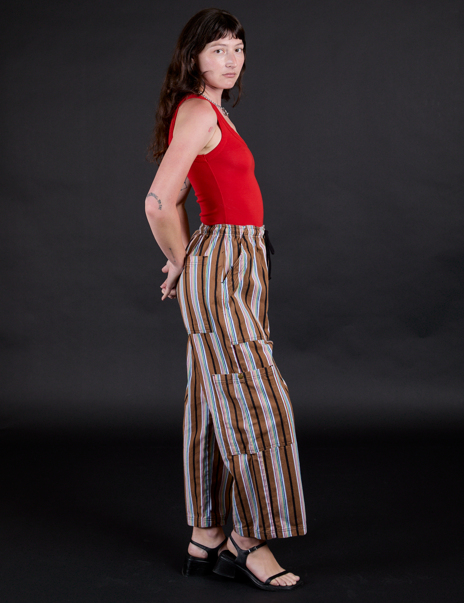 Side view of Striped Drop Pocket Pants in Retro Rainbow and mustang red Tank Top