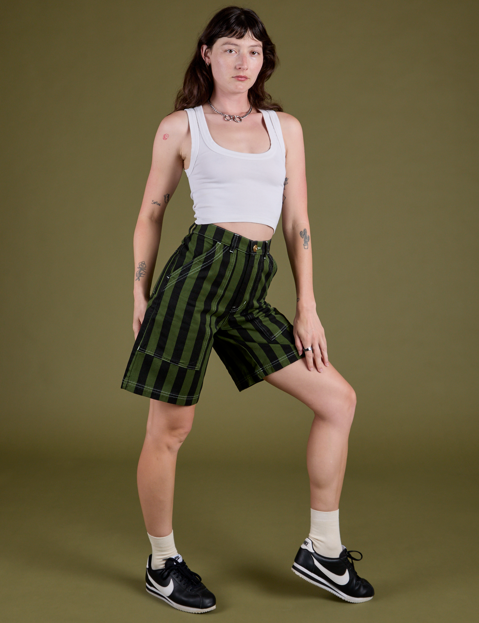 Angled front view of and Longline Work Shorts in Evergreen vintage tee white Cropped Tank on Alex