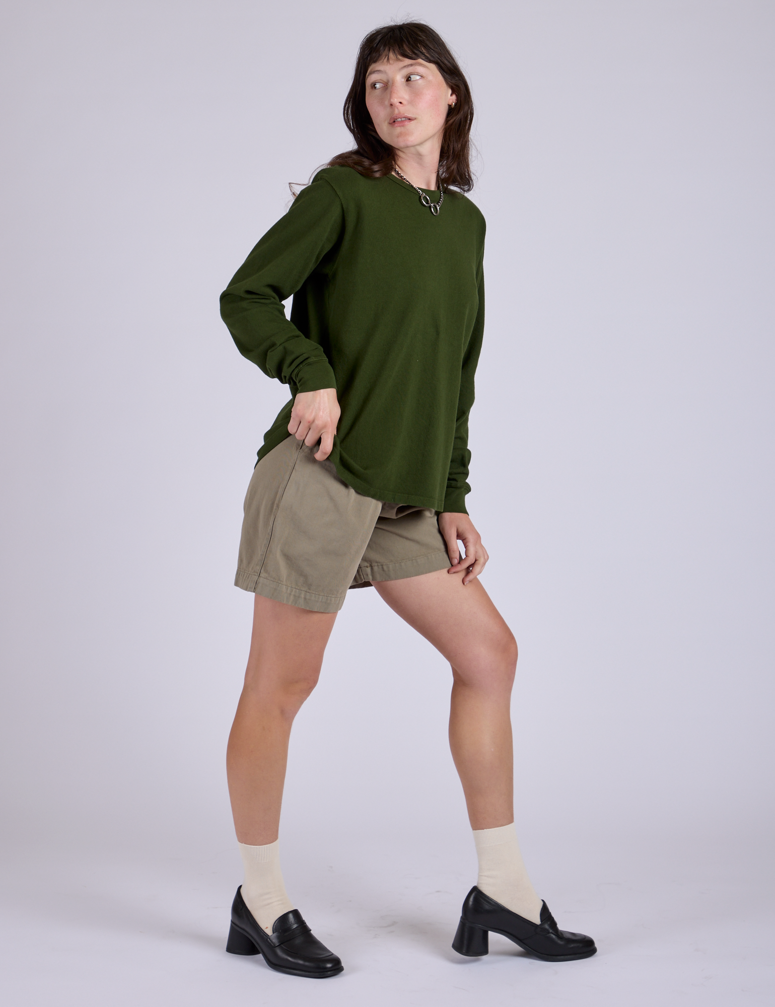Side view of Pleated Trouser Shorts in Khaki Grey and evergreen Long Sleeve Burly Tee on Alex