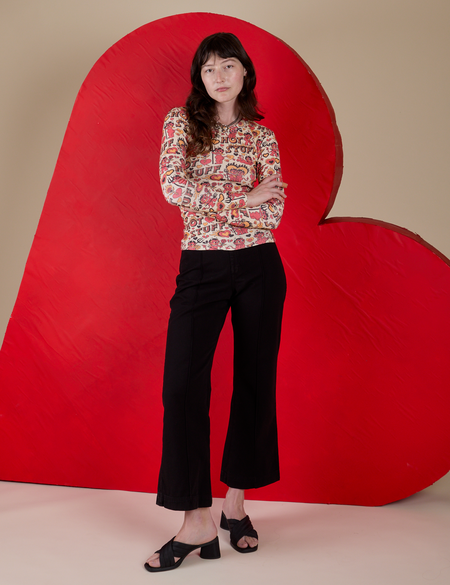 Alex is wearing Long Sleeve Baby Tee in Hot Stuff Print and black Western Pants