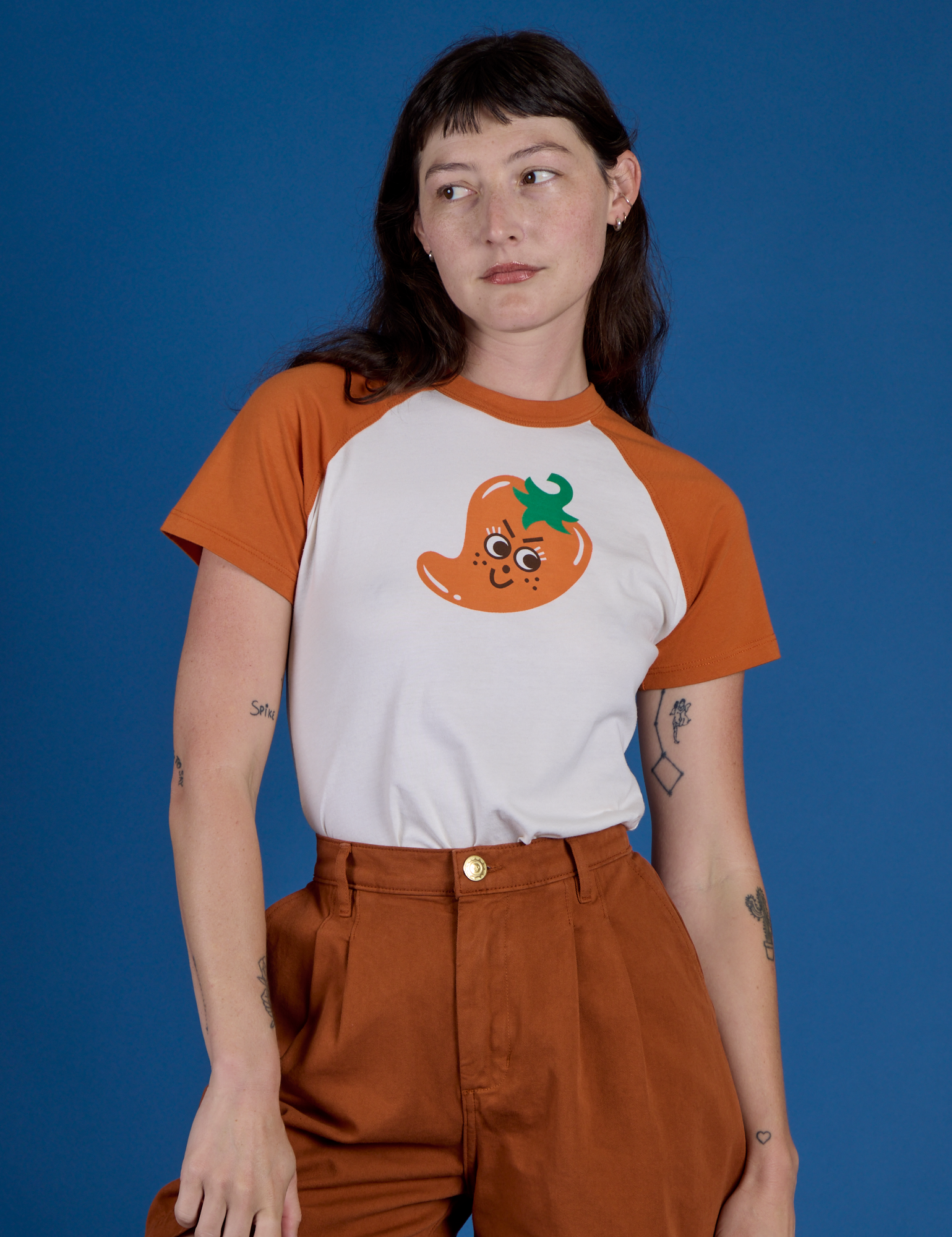 Alex is wearing Produce Raglan Tee in Habanero