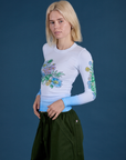 Angled front view of Floral Long Sleeve Baby Tee in Baby Blue on Madeline