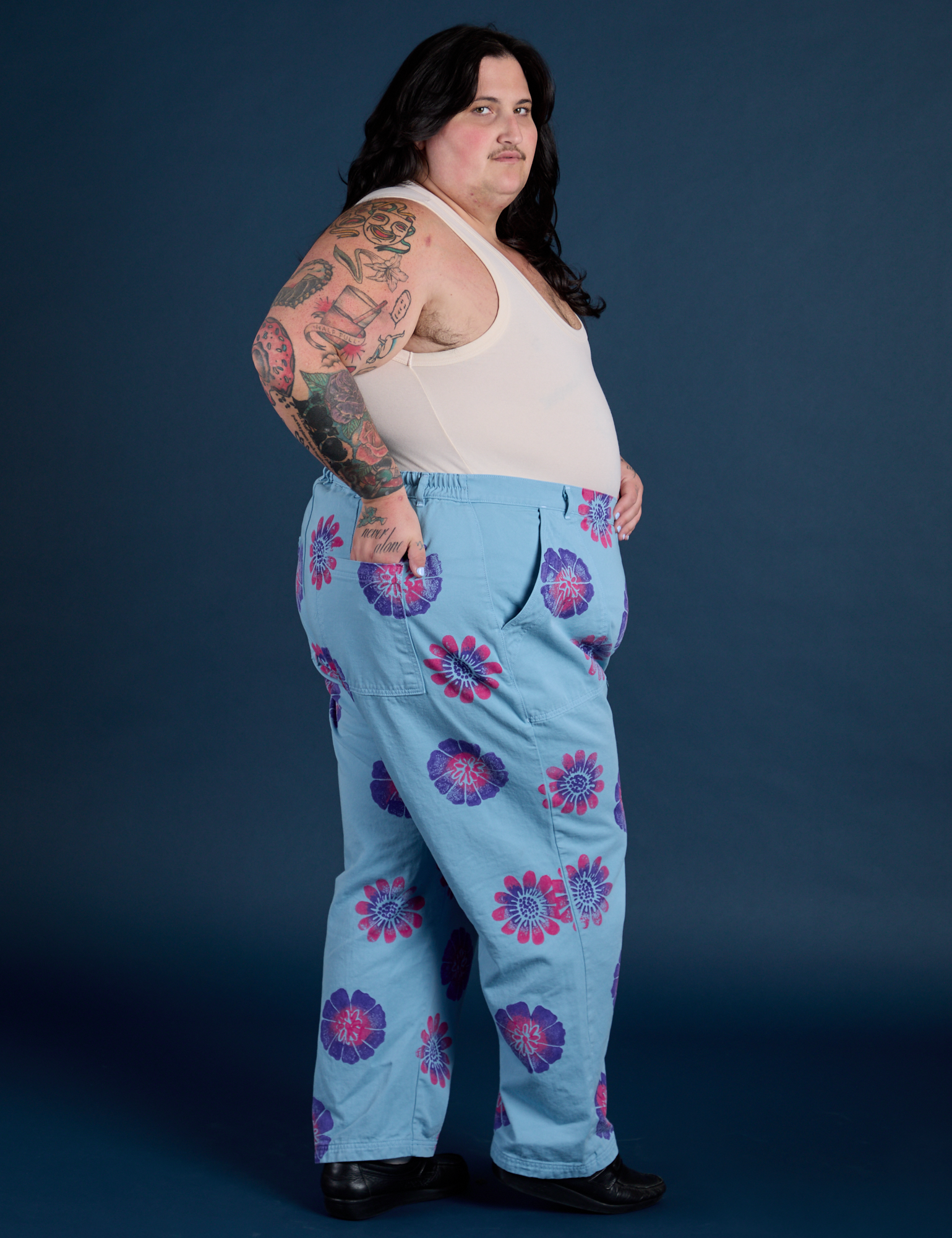 Side view. of Floral Painted Work Pants in Blue and Tank Top in Vintage Tee White