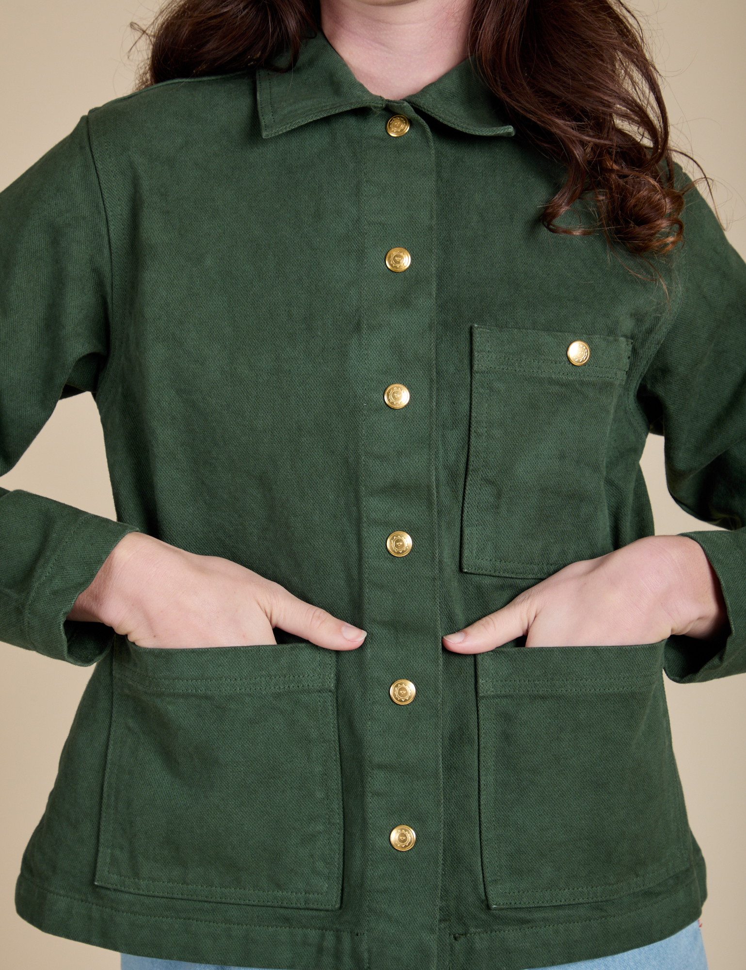 Alex has both hands in the front pocket of Denim Work Jacket in Swamp Green