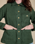 Alex has both hands in the front pocket of Denim Work Jacket in Swamp Green