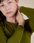 Close up of Long Sleeve Baby Tee in Summer Olive on Alex