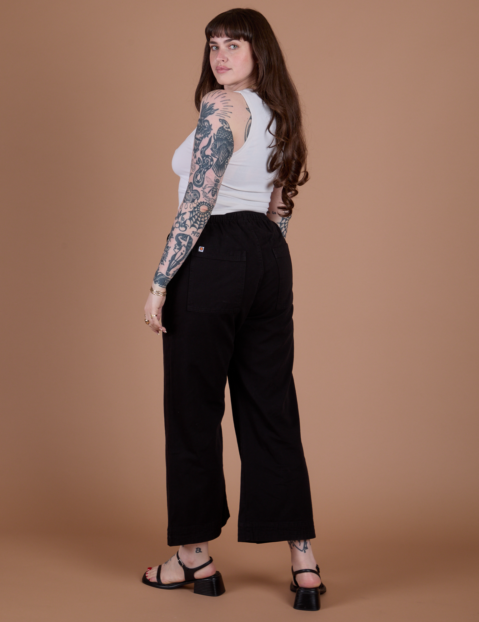 Angled back view of Action Pants in Basic Black and Cropped Tank in Vintage Tee White on Sydney