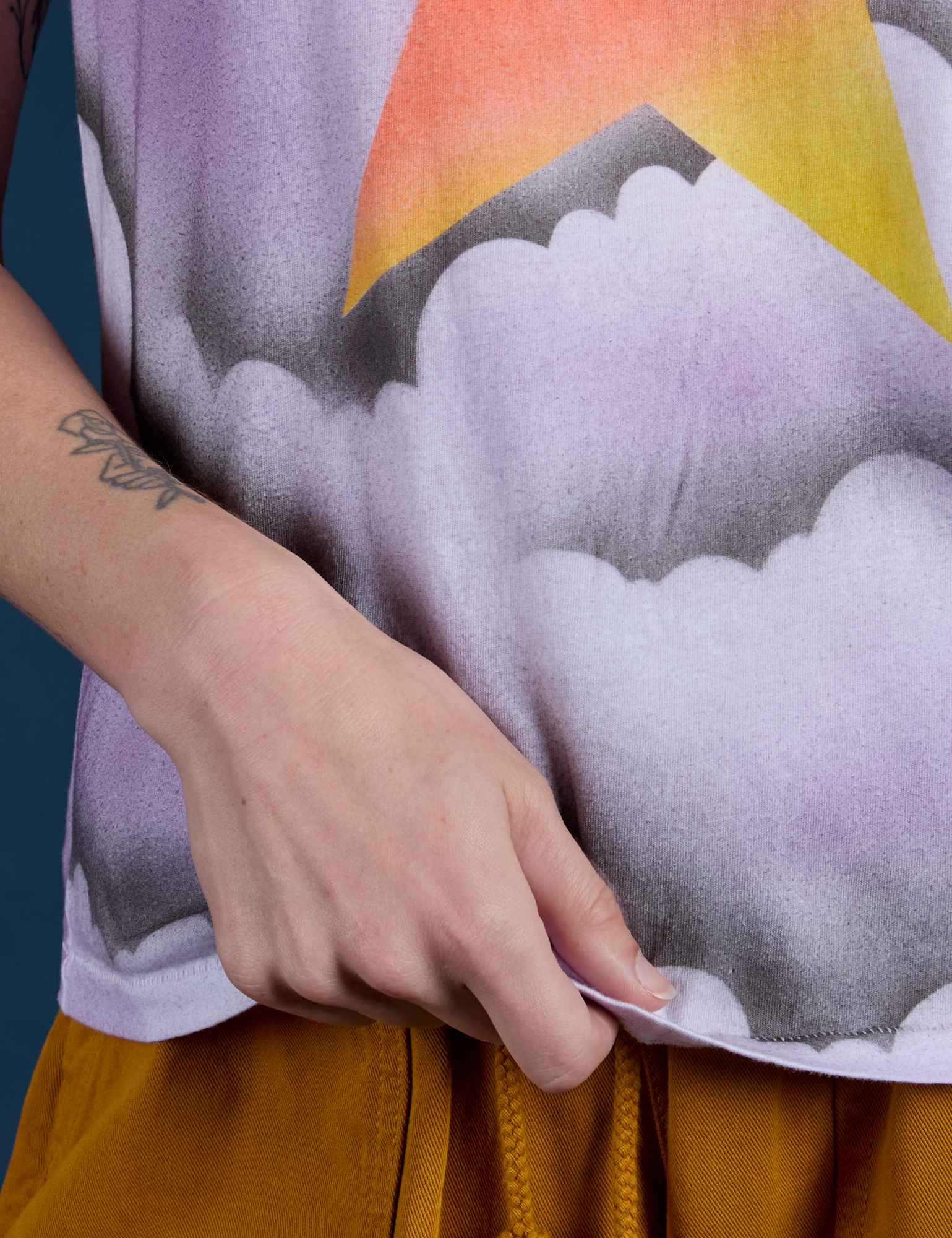 Alex is holding the hem of Airbrush Star Vintage Tee