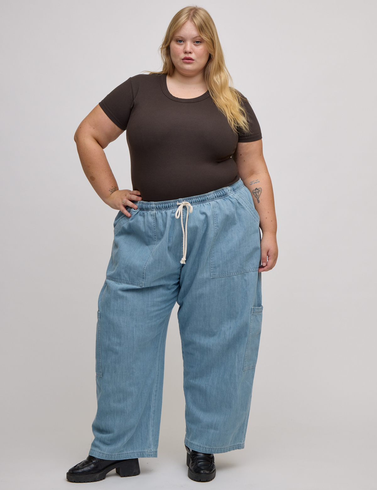 Juliet is wearing Baby Tee in Espresso Brown tucked into light wash denim drop pocket pants