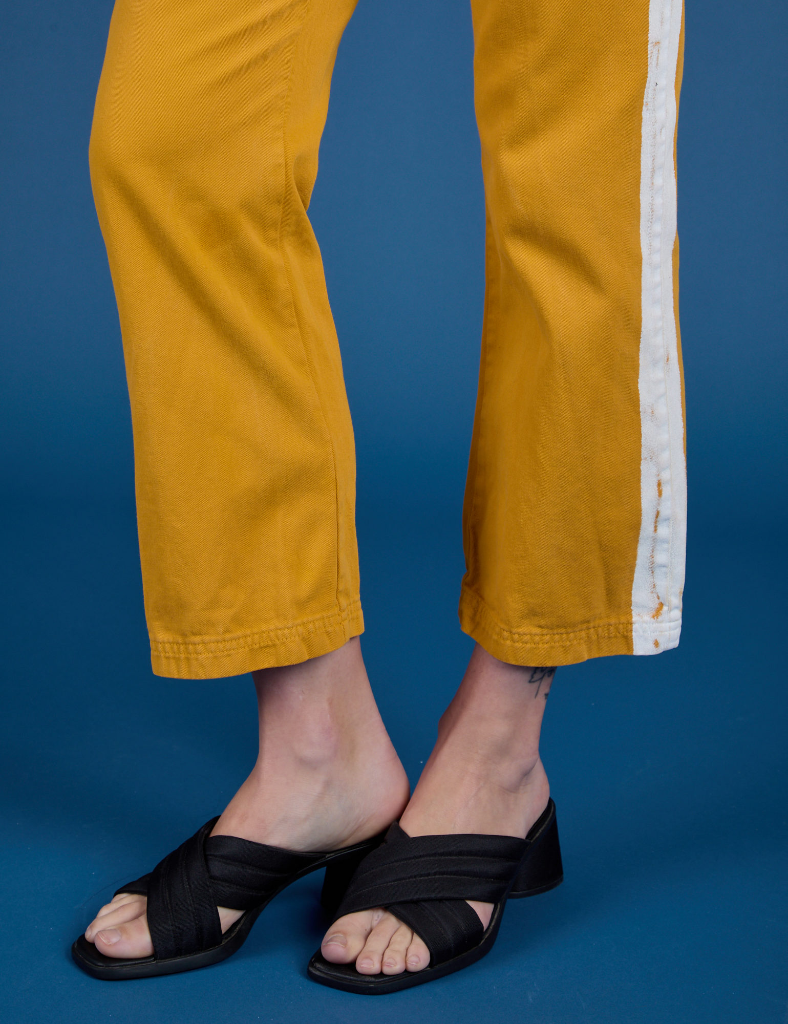 Painted Work Pants in Mustard Yellow pant leg close up on Alex