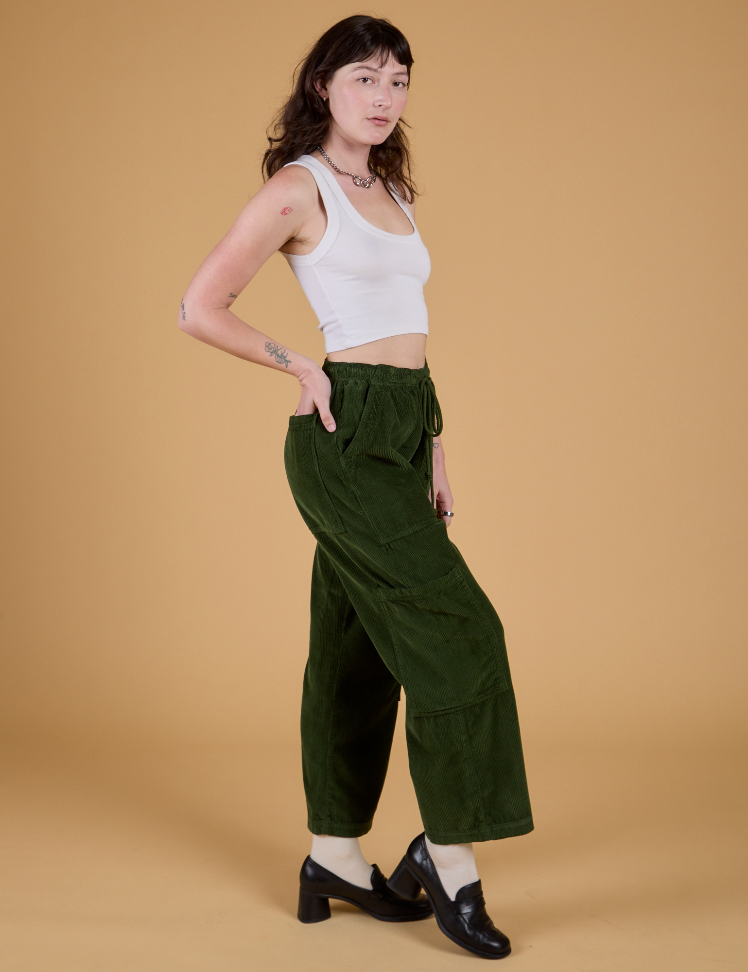 Side view of Corduroy Drop Pocket Cargo Pants in Evergreen and Cropped Tank in Vintage Tee White on Alex