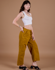 Side view of Drop Pocket Cargo Pants in Spicy Mustard and Cropped Tank in Vintage Tee white on Alex