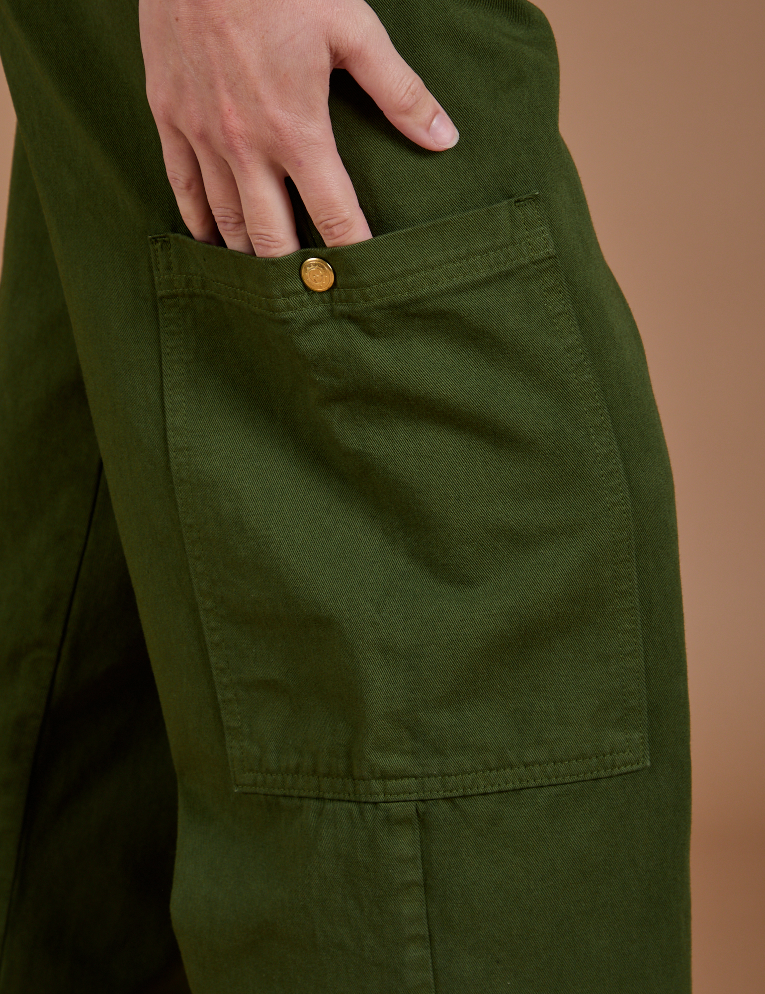 Close up of side leg pant pocket with Alex's hand tucked in
