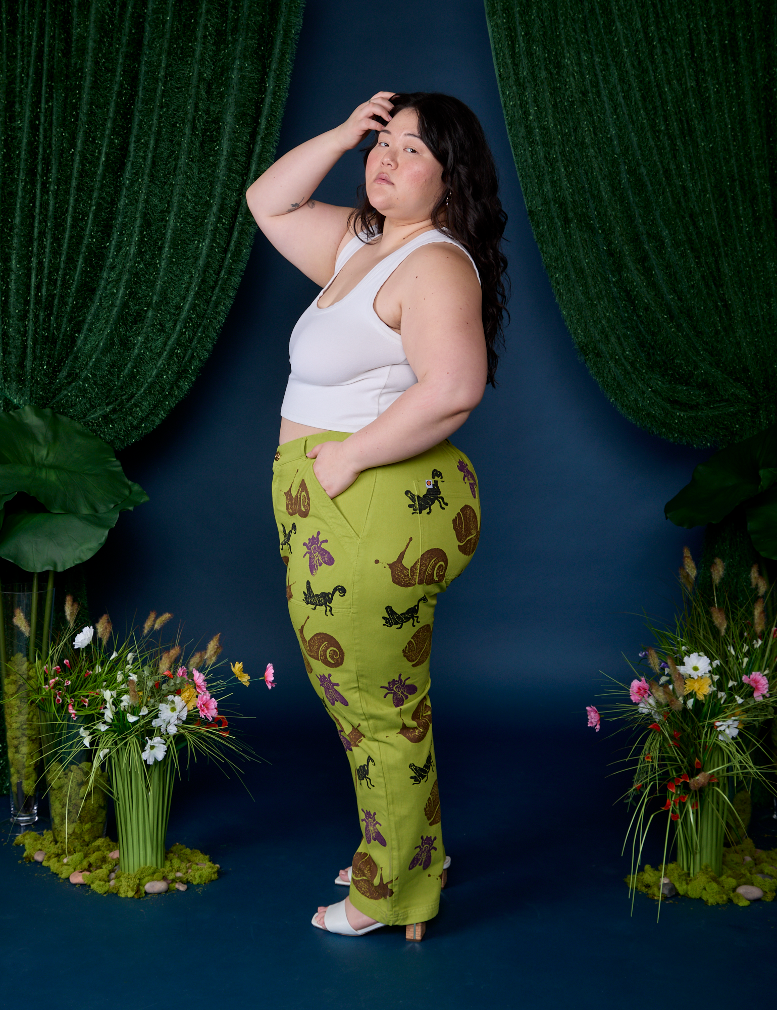 Side view of Paintstamped Work Pants in Froggy and vintage tee white Cropped Tank
