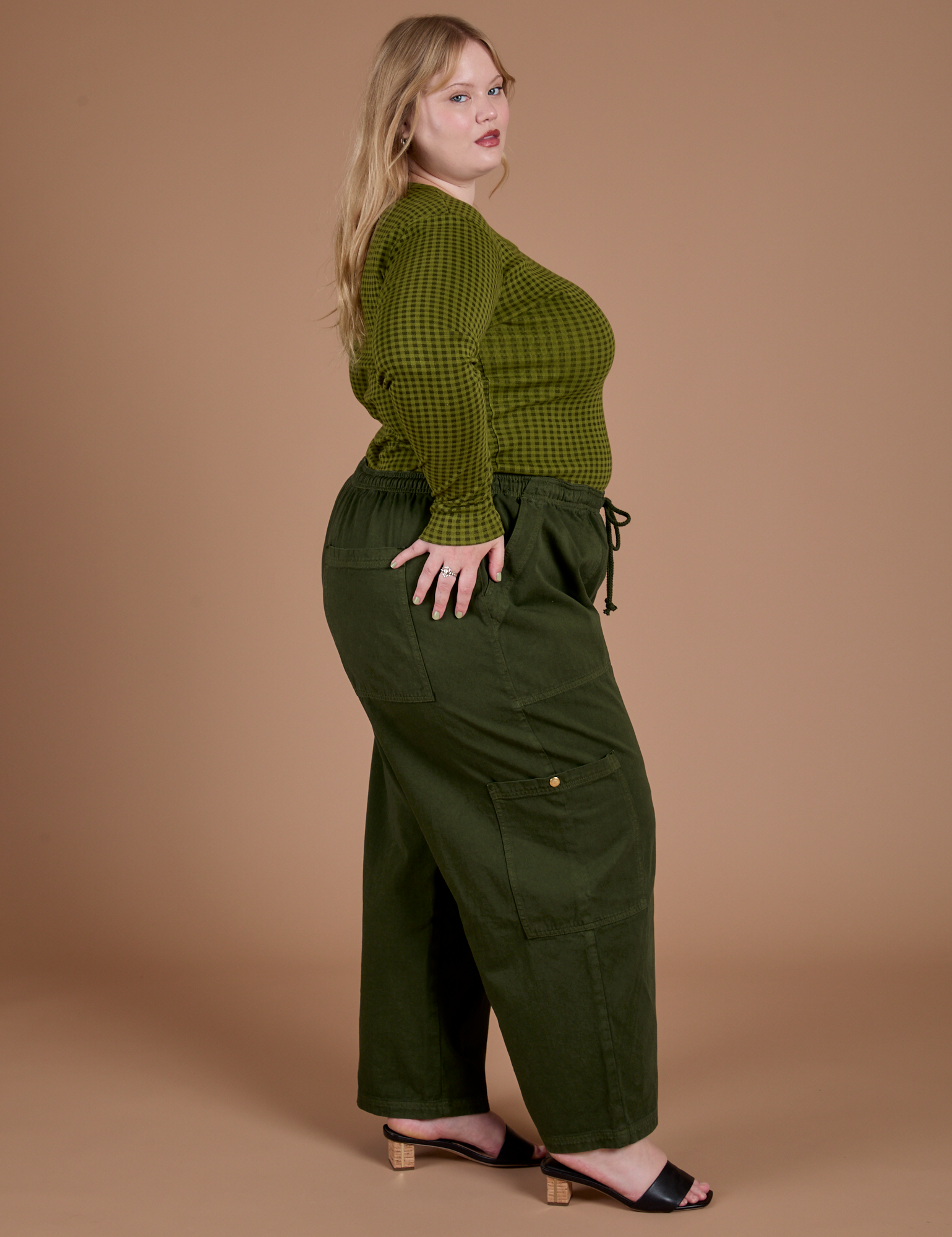 Side view of Gingham Long Sleeve Baby Tee in Summer Olive and evergreen Drop Pocket Cargo Pants