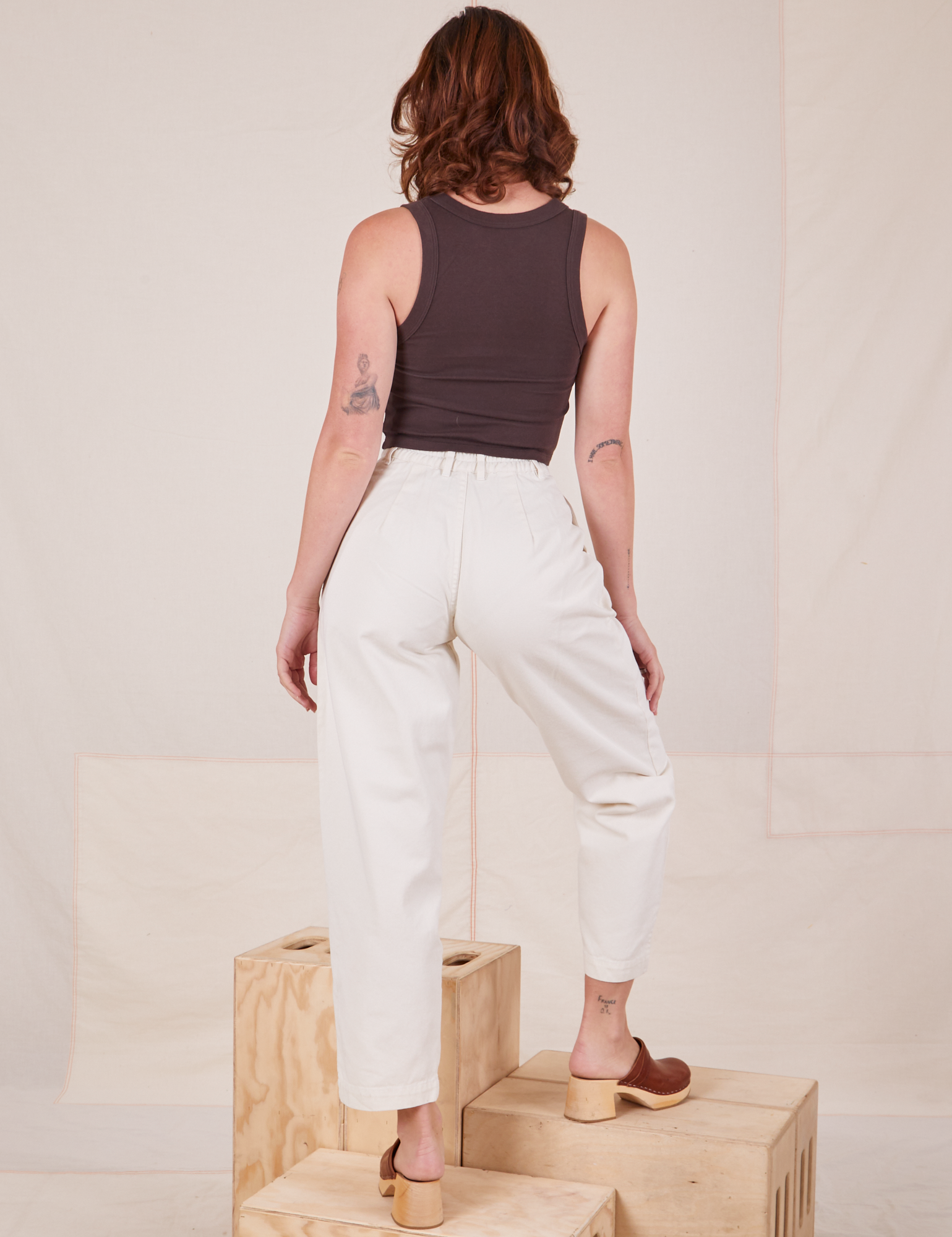 Back view of Heavyweight Trousers in Vintage Tee Off-White and espresso brown Tank Top worn by Alex.