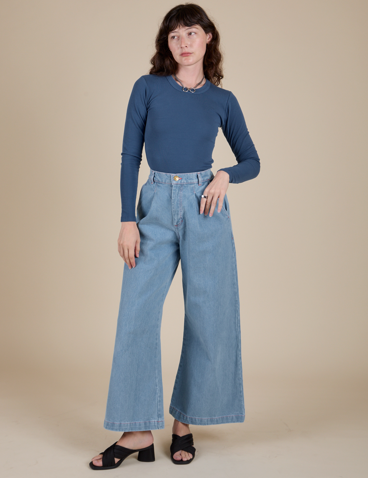 Alex is wearing Long Sleeve Baby Tee in French Blue and light wash Indigo Wide Leg Trousers