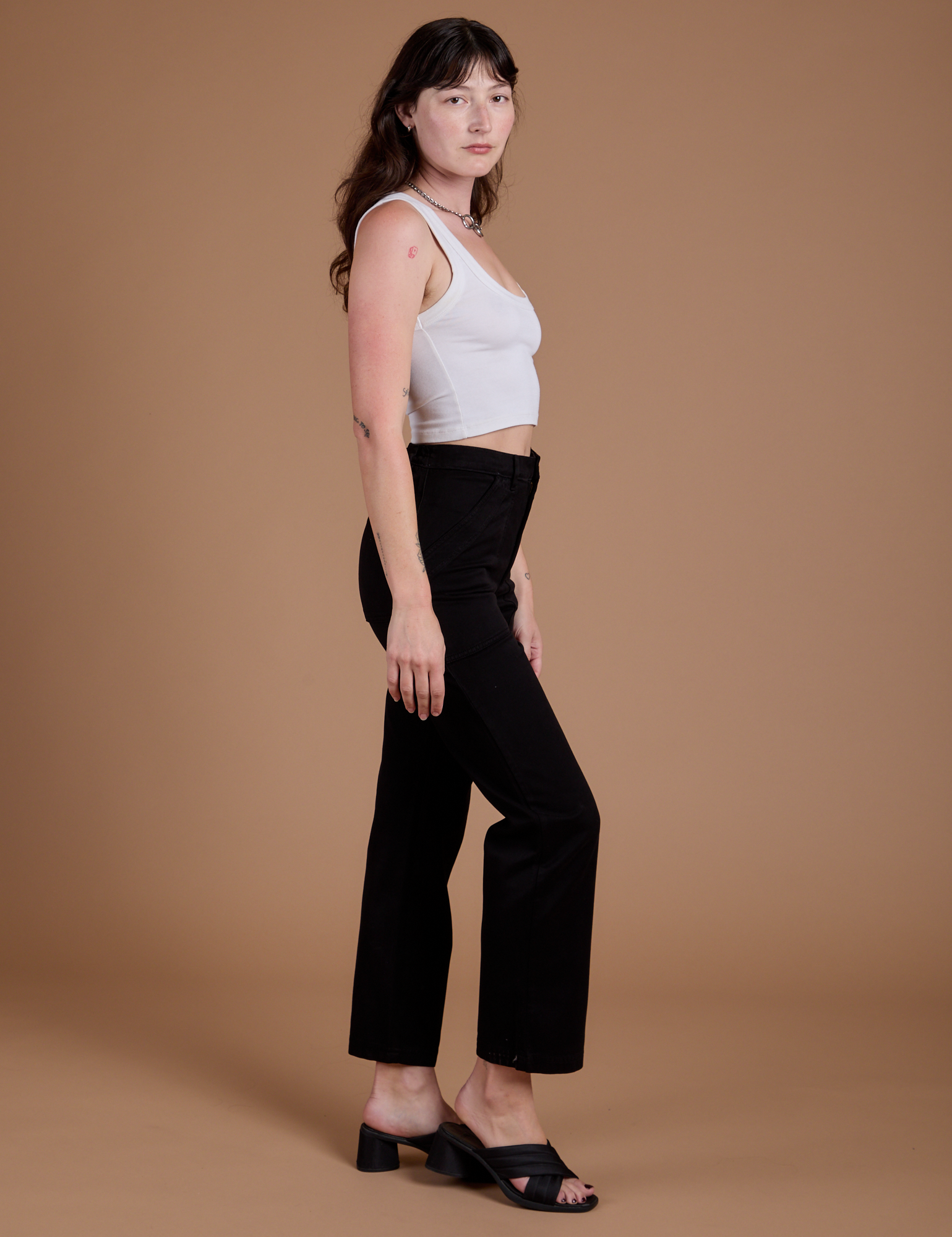 Side view of Organic Work Pants in Basic Black and vintage tee white Cropped Tank on Alex