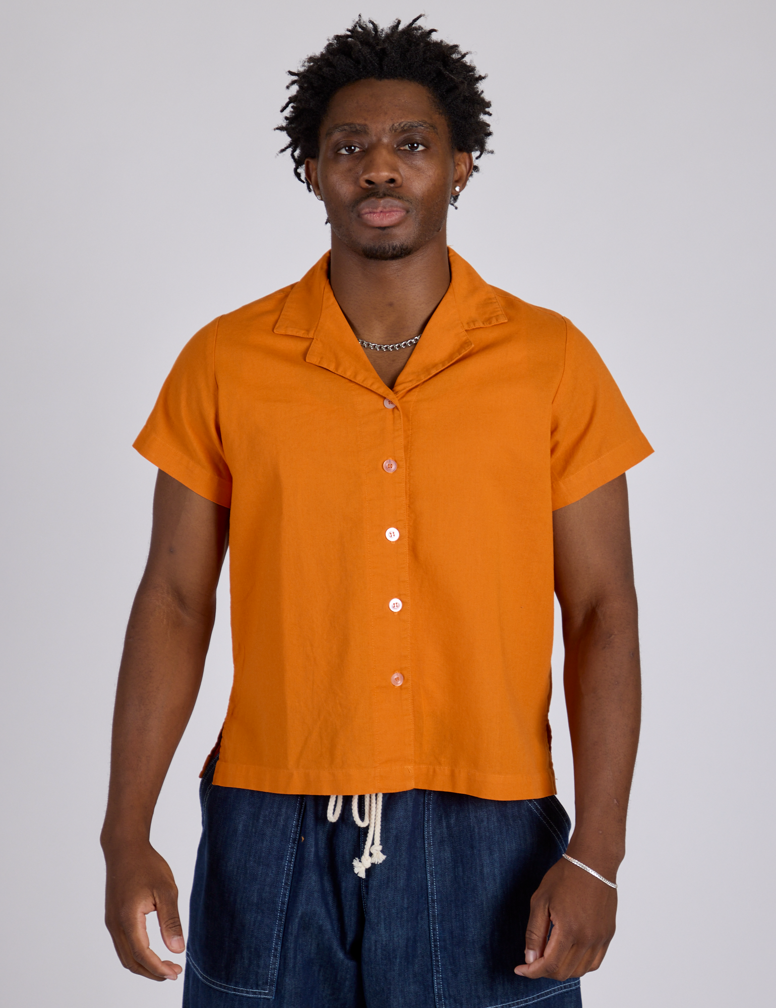isaac is wearing Pantry Button-Up in Creamsicle Orange